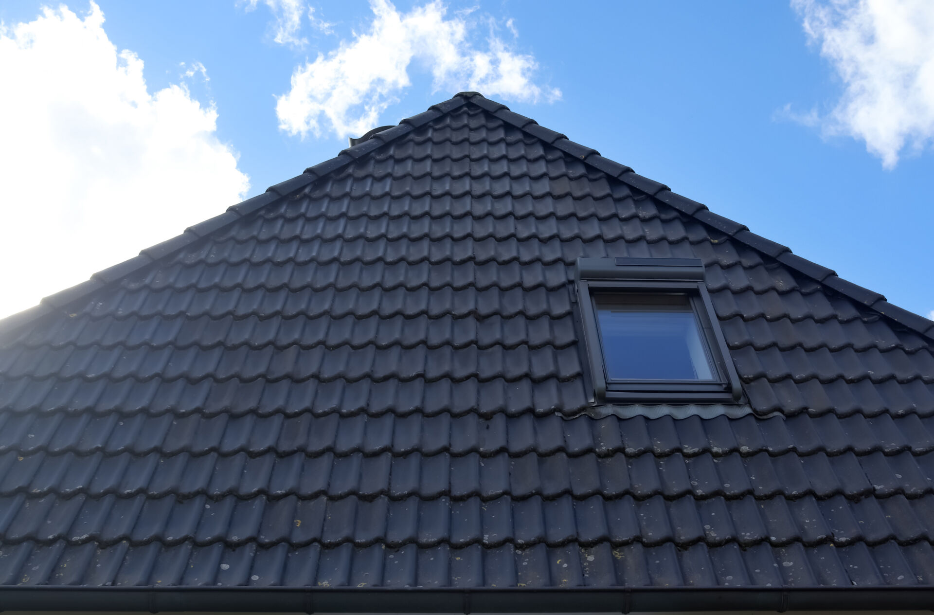 A low angle of the black clay tile roof of a house